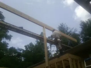 Carpenter setting a ridge beam over a new addition frame — Ice Dam Removal by Roofing Brothers in Mound Valley