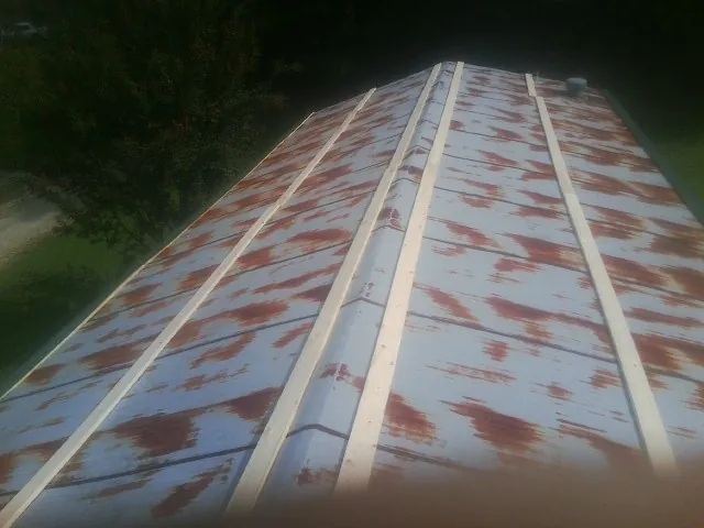 Rusted metal roof panels with new wood purlins before replacement — Storm Damage Roof Repair in Mound Valley by Roofing Brothers