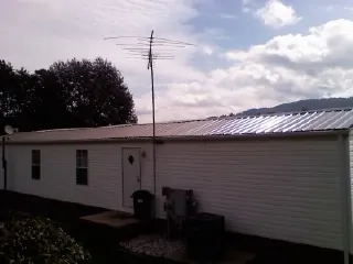 New metal roof on a single wide mobile home with a TV antenna in Mound Valley