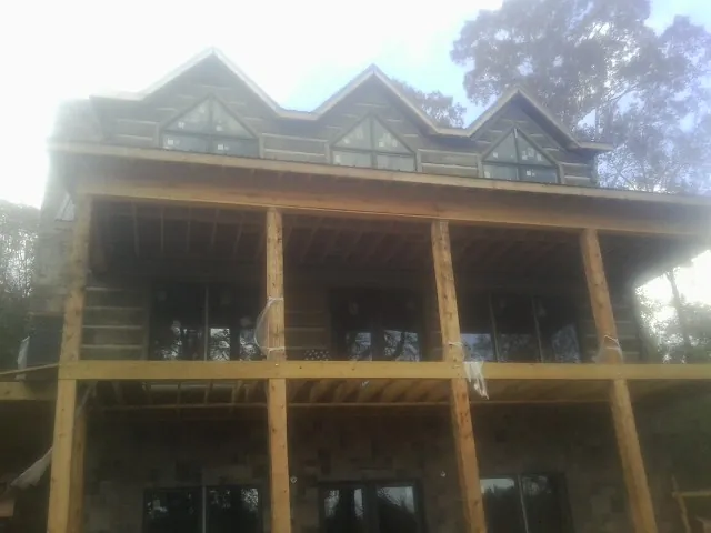 Dormers and porch framing on a large log home under construction — Roof Coating work by our crew in Mound Valley