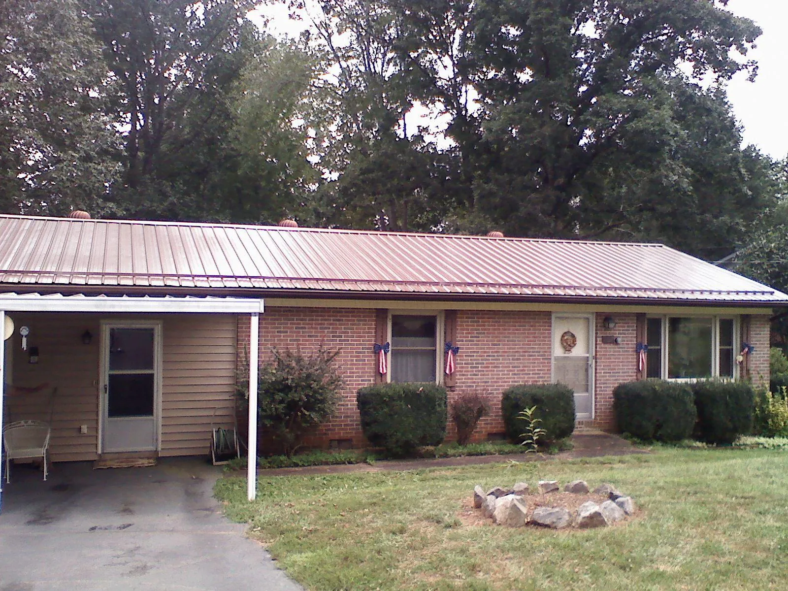 Bronze metal roof and carport on a brick ranch home — Roof Repair work by our crew in Mound Valley