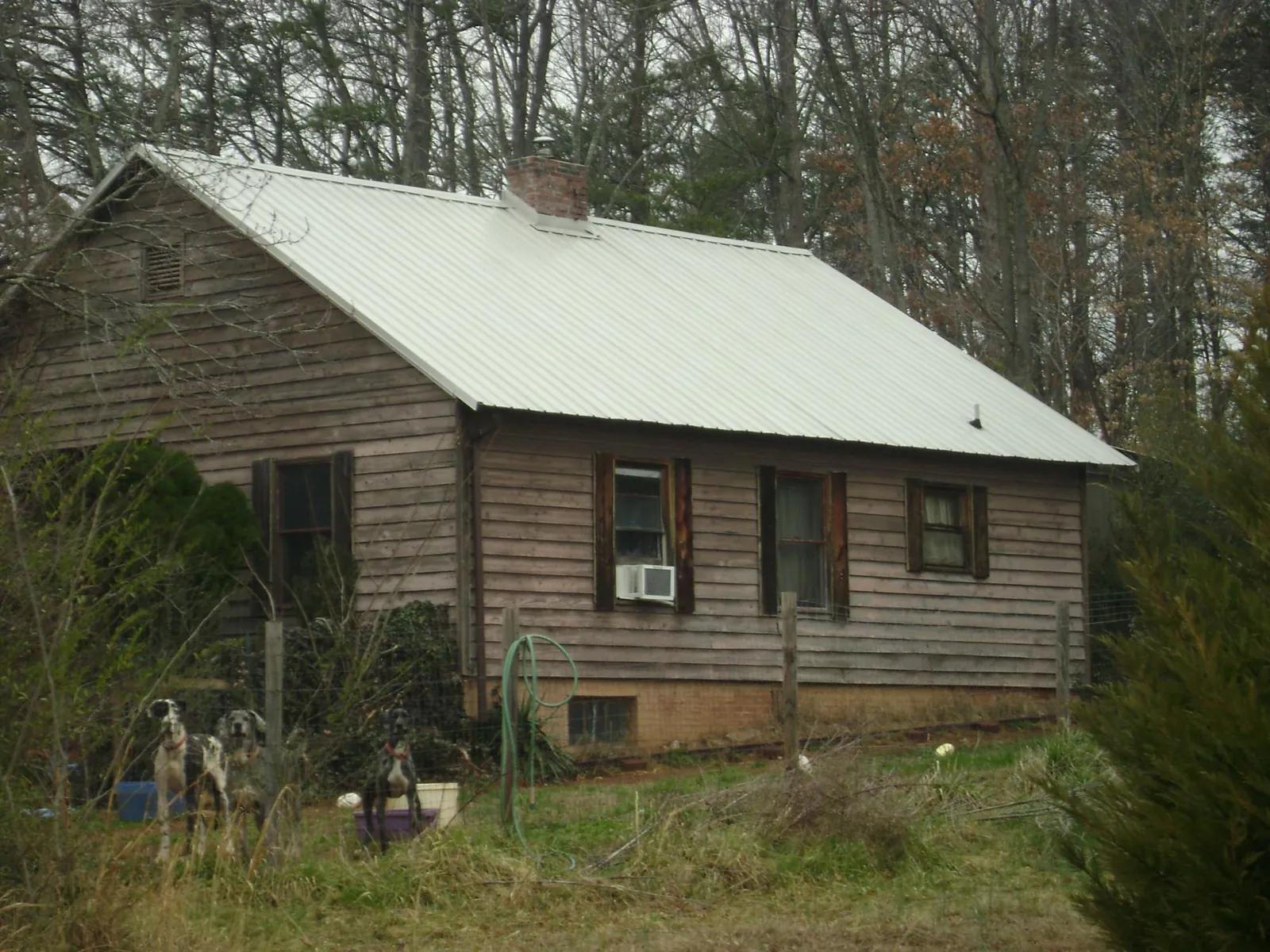 White metal roof on an old wood sided farmhouse, from a Asphalt Shingle Roof Repair job in Mound Valley